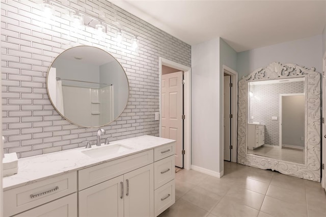 bathroom featuring tile patterned floors, tasteful backsplash, vanity, and tile walls