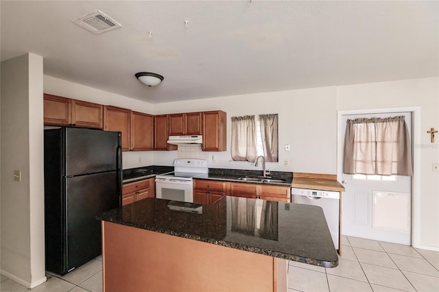 kitchen featuring plenty of natural light, light tile patterned floors, white appliances, and a kitchen island