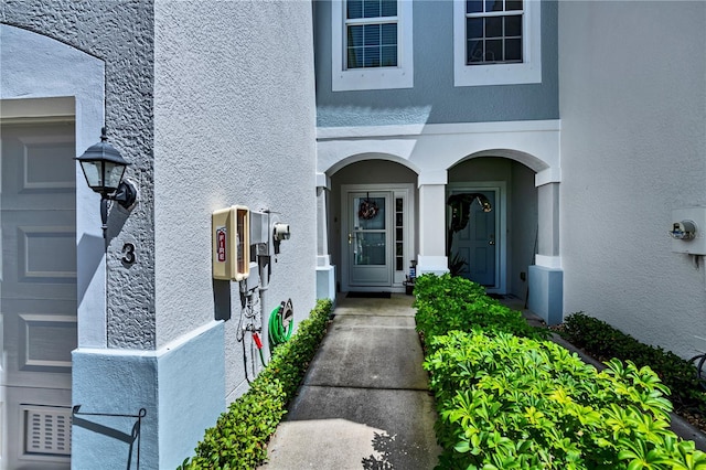 view of exterior entry featuring stucco siding and an attached garage