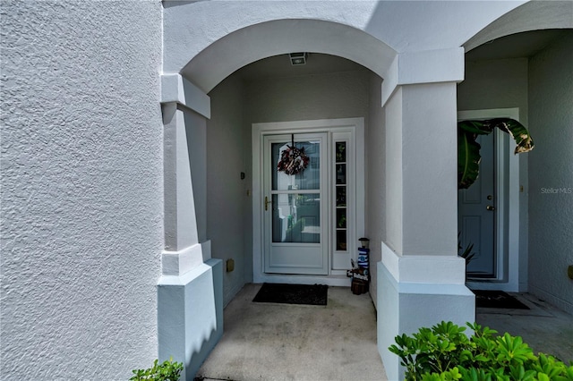 view of exterior entry featuring stucco siding