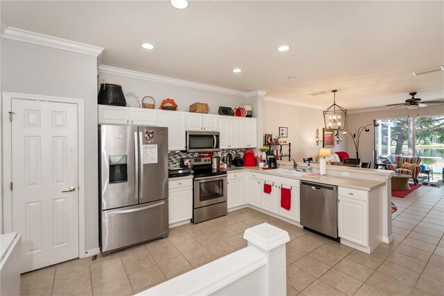 kitchen with ceiling fan with notable chandelier, light tile patterned floors, stainless steel appliances, and kitchen peninsula