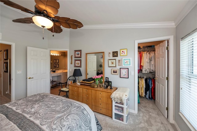 bedroom with light carpet, ensuite bath, a closet, crown molding, and a spacious closet