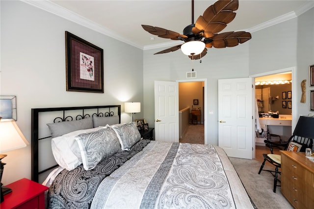 bedroom featuring ceiling fan, carpet flooring, ensuite bath, and crown molding