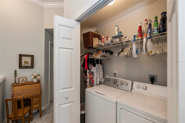 laundry area with crown molding, washing machine and clothes dryer, and light carpet