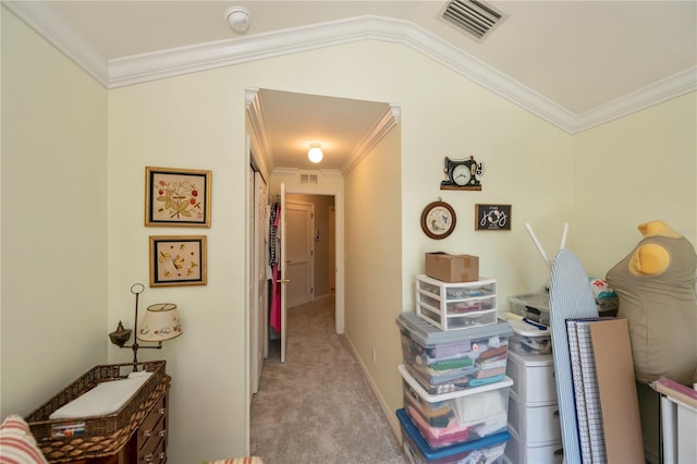 hallway featuring light colored carpet, visible vents, and ornamental molding