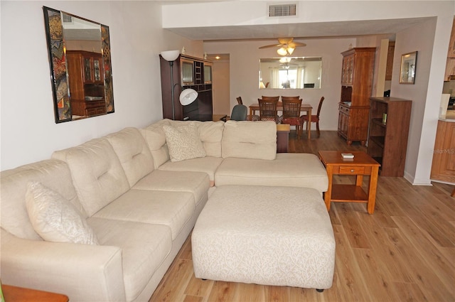 living room featuring light hardwood / wood-style flooring and ceiling fan