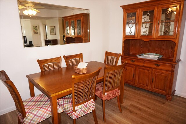 dining space with ceiling fan and wood-type flooring