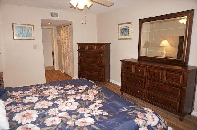 bedroom with ceiling fan, a closet, and dark hardwood / wood-style floors