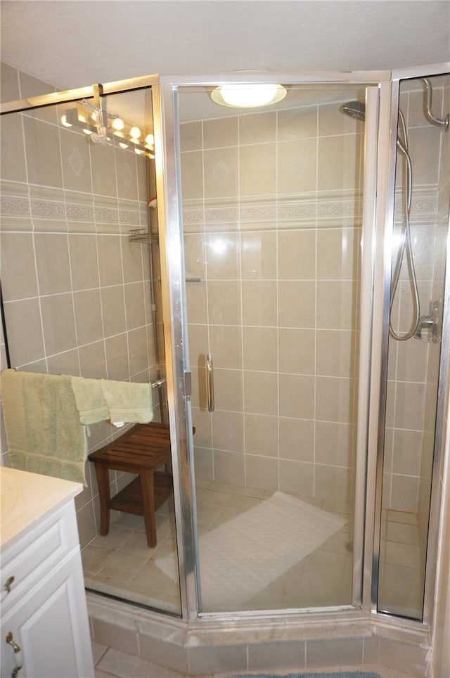 bathroom featuring vanity, walk in shower, and tile patterned floors