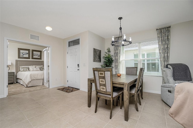 dining area with light tile patterned floors and a chandelier