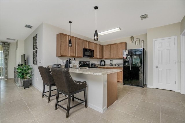 kitchen with hanging light fixtures, kitchen peninsula, a breakfast bar area, black appliances, and light tile patterned flooring