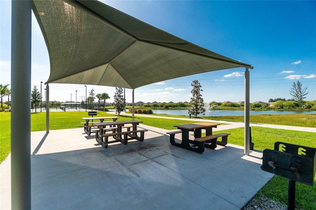 view of community featuring a patio, a yard, and a water view