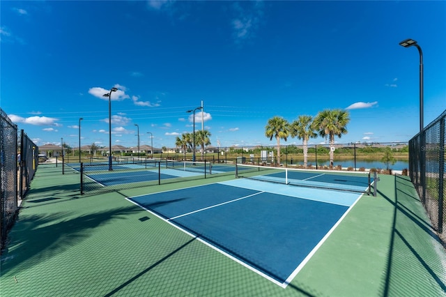 view of tennis court with a water view