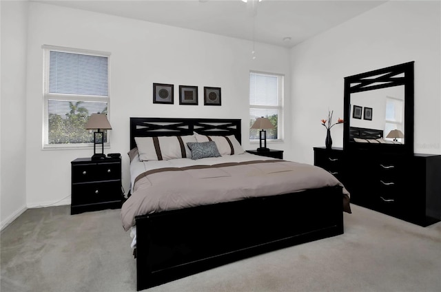 bedroom featuring light colored carpet and multiple windows