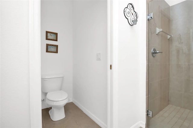 bathroom with toilet, tiled shower, and tile patterned floors