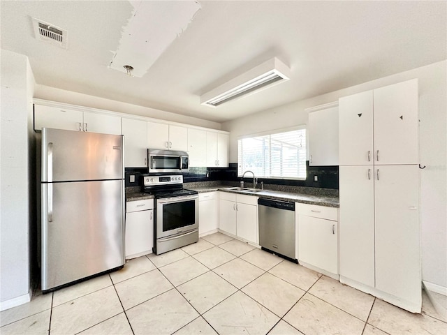 kitchen featuring sink, light tile patterned floors, white cabinetry, and stainless steel appliances