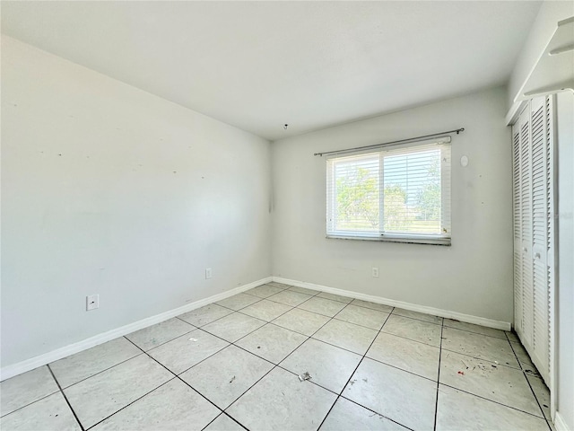 unfurnished bedroom with a closet and light tile patterned floors