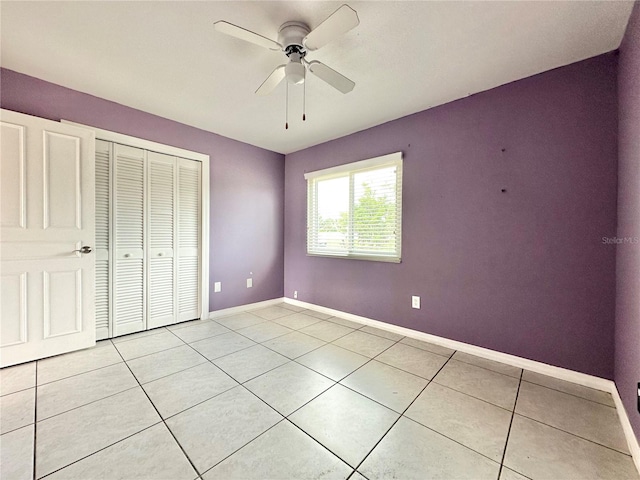 unfurnished bedroom featuring a closet, ceiling fan, and light tile patterned floors