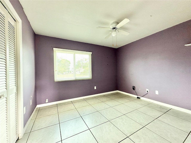 tiled spare room with ceiling fan