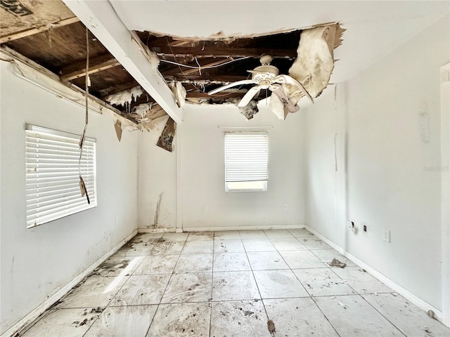 tiled spare room featuring ceiling fan