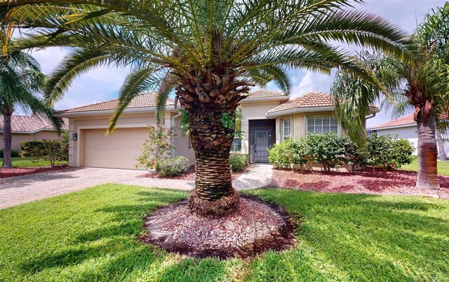 mediterranean / spanish-style home featuring a garage and a front yard