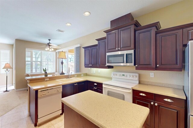 kitchen with a center island, sink, appliances with stainless steel finishes, and ceiling fan