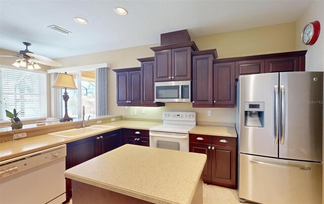 kitchen with sink, ceiling fan, a center island, and stainless steel appliances