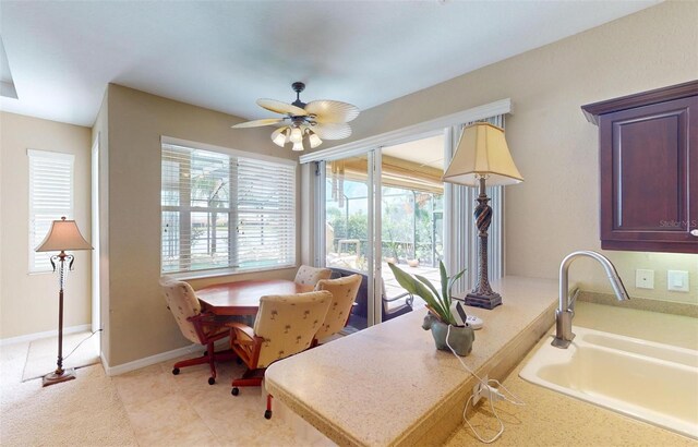 kitchen with sink, light tile patterned floors, and ceiling fan