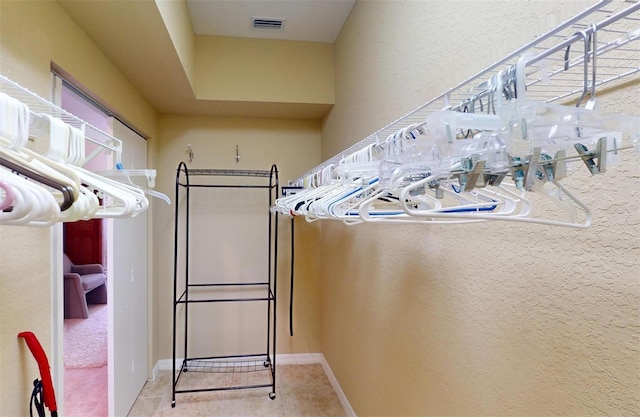 walk in closet with light tile patterned floors