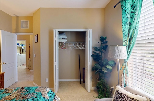 carpeted bedroom with independent washer and dryer and a closet