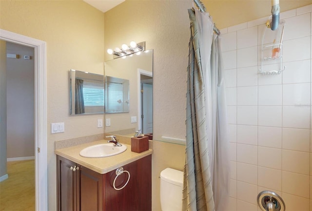 bathroom with a shower with shower curtain, vanity, and toilet