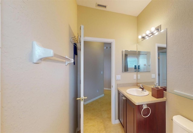 bathroom featuring tile patterned flooring, toilet, and vanity