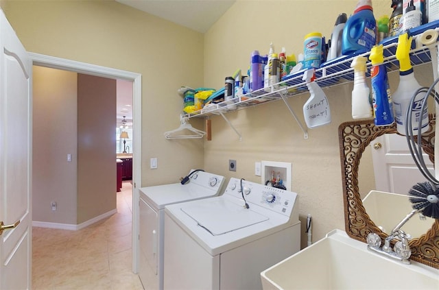 laundry area with sink, light tile patterned floors, and separate washer and dryer