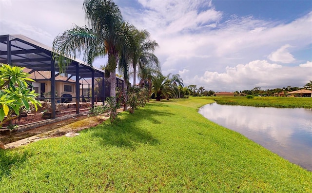 view of yard featuring a lanai and a water view