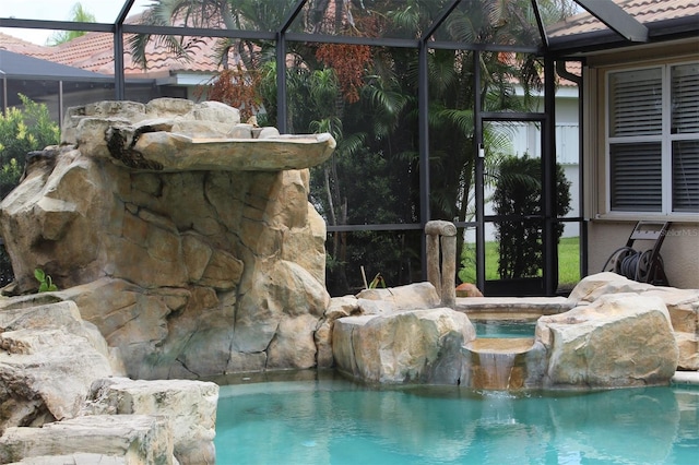 view of swimming pool featuring a lanai