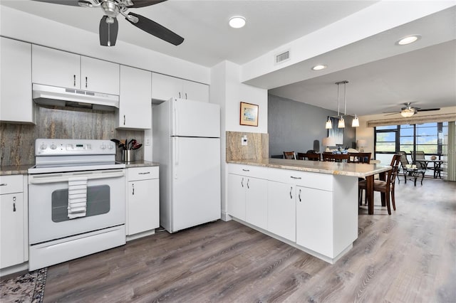 kitchen featuring white appliances, white cabinets, hardwood / wood-style flooring, decorative backsplash, and kitchen peninsula