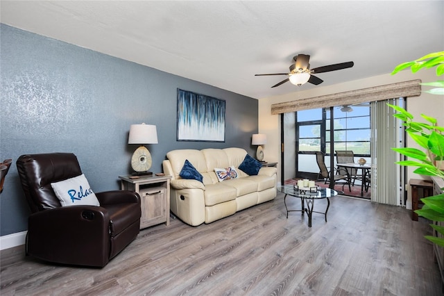 living room featuring ceiling fan and light hardwood / wood-style flooring