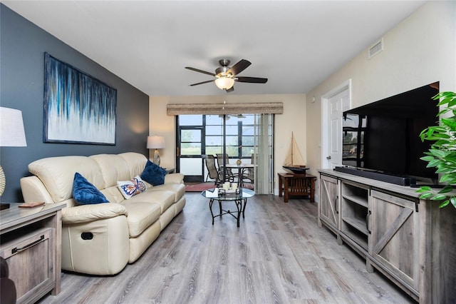 living room featuring ceiling fan and light hardwood / wood-style flooring