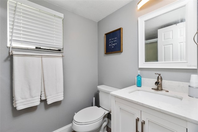 bathroom featuring vanity, a textured ceiling, and toilet