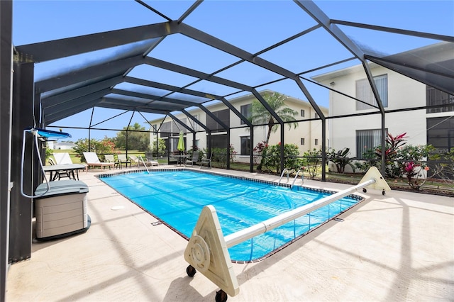 view of pool with glass enclosure and a patio area