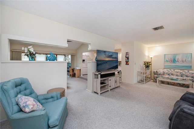 living room featuring light colored carpet, visible vents, and a textured ceiling