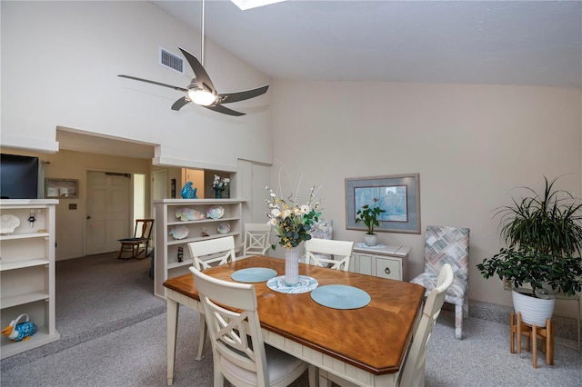 dining space with a ceiling fan, visible vents, high vaulted ceiling, and light carpet