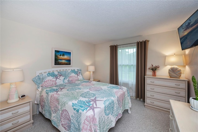 bedroom with a textured ceiling and light carpet