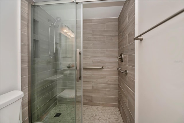 bathroom featuring a stall shower and toilet