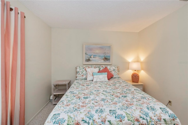 bedroom with carpet flooring, a textured ceiling, and baseboards