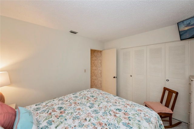 bedroom with a textured ceiling, a closet, and visible vents