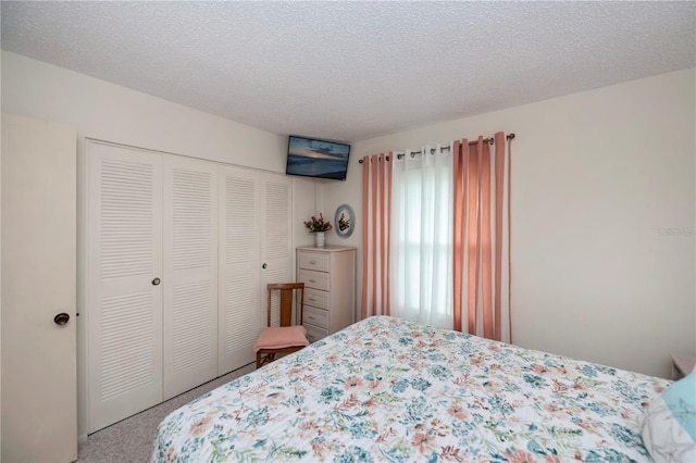 bedroom with carpet floors, a textured ceiling, and a closet