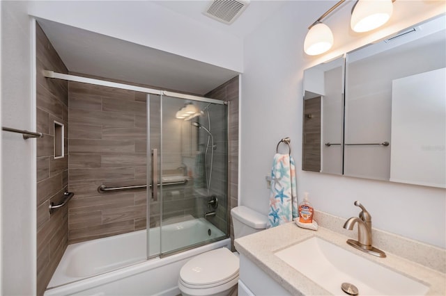 bathroom with toilet, visible vents, combined bath / shower with glass door, and vanity