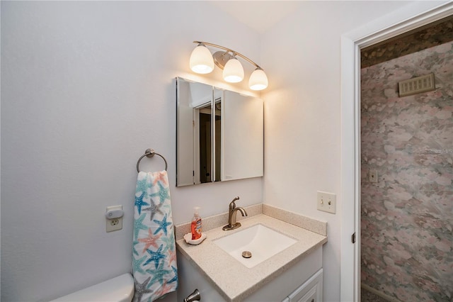 bathroom featuring toilet and vanity