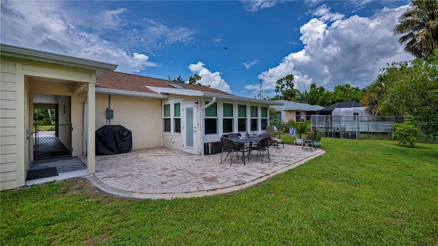 rear view of house featuring stucco siding, a patio area, a yard, and fence